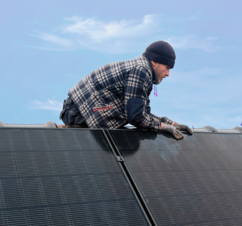Installateur auf einem Dach mit Photovoltaikanlage